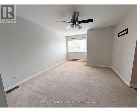 A spacious room with a ceiling fan and a window.