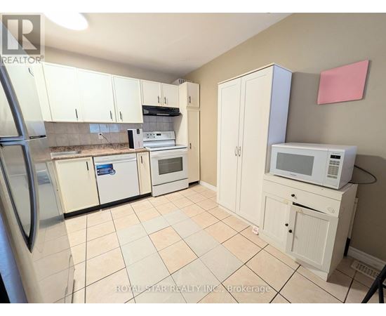 A kitchen with white cabinets and appliances.