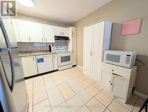 A kitchen with white cabinets and appliances.