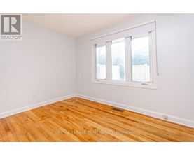 A room with wooden flooring and a whiteboard on the wall.
