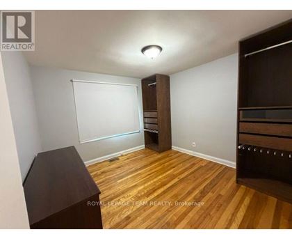 A room with wooden flooring and a whiteboard on the wall.