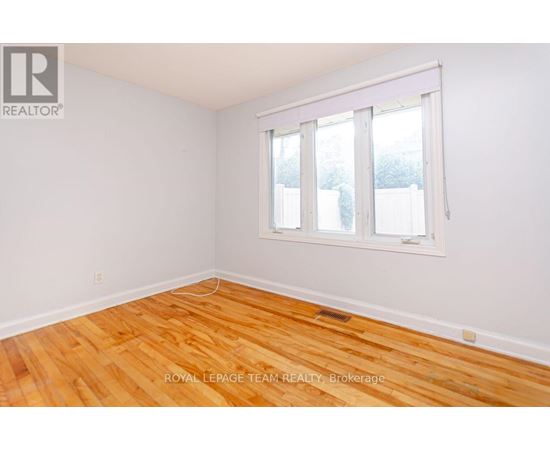 A room with wooden flooring and a whiteboard on the wall.
