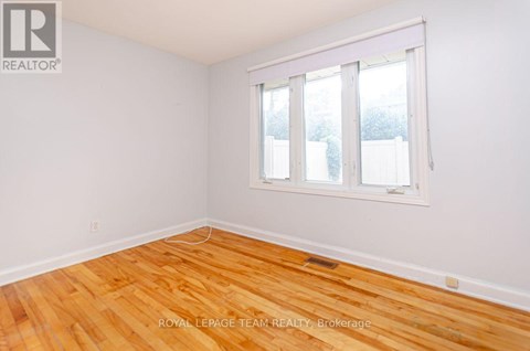 A room with wooden flooring and a whiteboard on the wall.