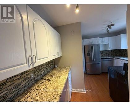 A kitchen with white cabinets and a granite countertop.