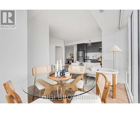 A modern dining room with a glass table and chairs.