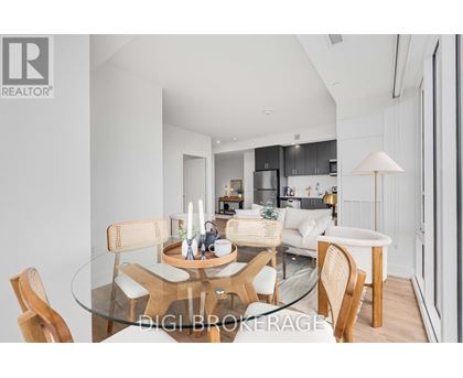 A modern dining room with a glass table and chairs.