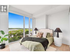 A bedroom with a large bed and a view of the city.