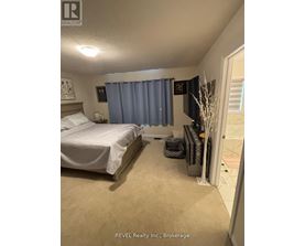 A bedroom with a bed, nightstand, and a window with blue curtains.