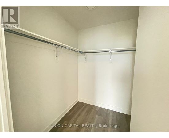 A white bedroom with a bed frame and no bed.