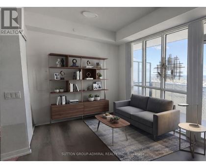 A living room with a grey couch, a wooden table, and a large window.