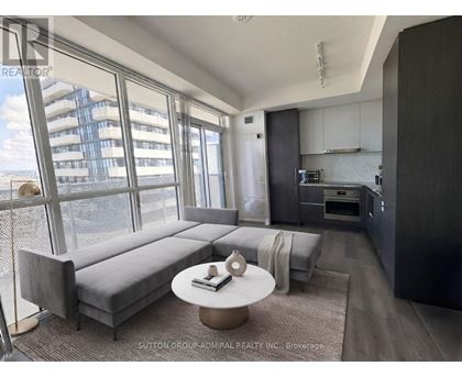 A modern living room with a grey sofa and a round coffee table.