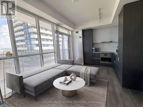 A modern living room with a grey sofa and a round coffee table.