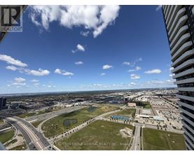A view from a high-rise building looking out over a cityscape with a clear blue sky.