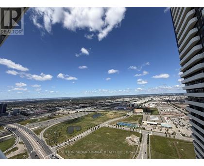 A view from a high-rise building looking out over a cityscape with a clear blue sky.
