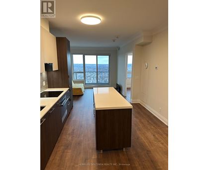 A kitchen with dark wood cabinets and a white countertop.