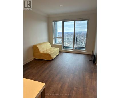 A living room with a yellow chair and a view of the city.