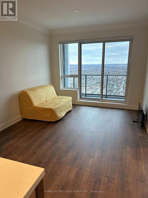 A living room with a yellow chair and a view of the city.