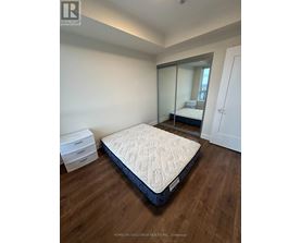 A bedroom with a large bed and a mirrored closet door.