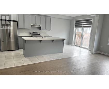 A modern kitchen with a stainless steel refrigerator and a central island.