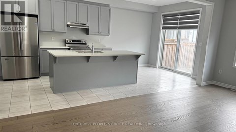A modern kitchen with a stainless steel refrigerator and a central island.