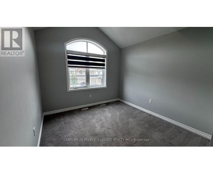 A room with a window showing a view of a building and trees outside.