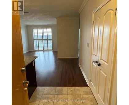 A room with wooden floors and white walls, with a door on the right side.