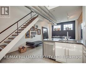 A modern kitchen with a staircase leading to the upper floor.