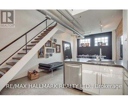 A modern kitchen with a staircase leading to the upper floor.