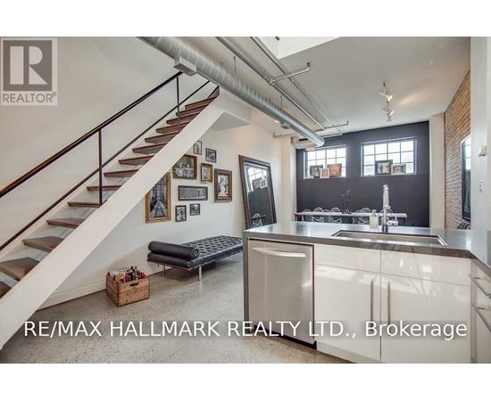 A modern kitchen with a staircase leading to the upper floor.