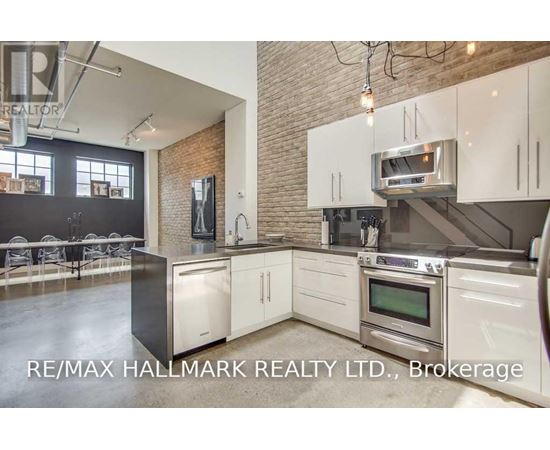 A modern kitchen with white cabinets and stainless steel appliances.