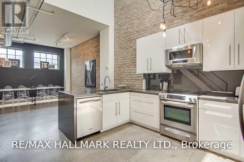 A modern kitchen with white cabinets and stainless steel appliances.