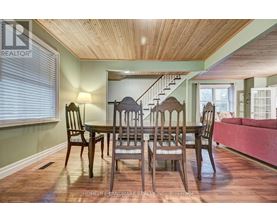 A dining room with a wooden table and chairs.