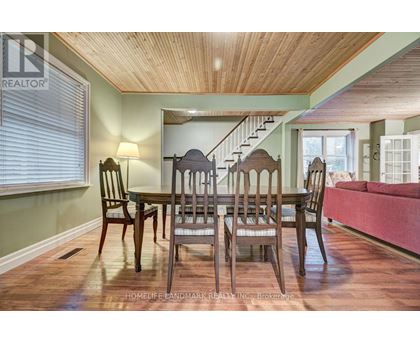 A dining room with a wooden table and chairs.