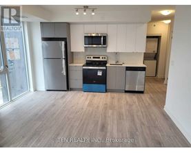 A kitchen with a refrigerator, stove, and microwave.