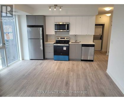 A kitchen with a refrigerator, stove, and microwave.