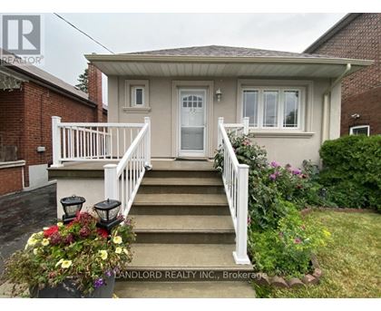 A house with a front porch and stairs leading to the door.