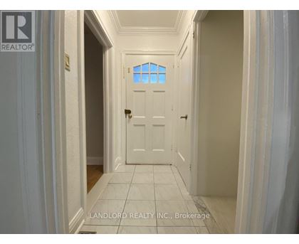 A hallway with a white door and a window above it.