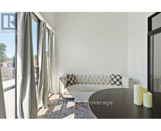 A living room with a white sofa and a black and white checkered pillow.