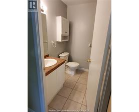 A bathroom with a toilet, sink and medicine cabinet.