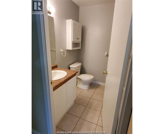 A bathroom with a toilet, sink and medicine cabinet.