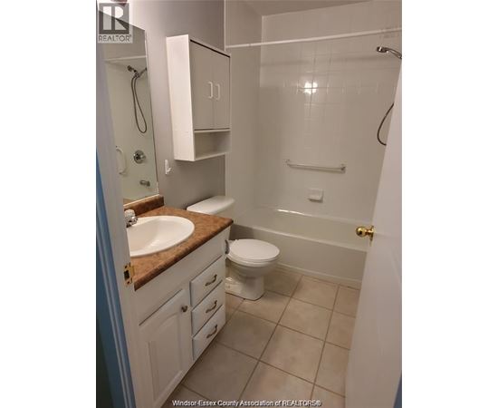 A bathroom with a toilet, sink, and shower.