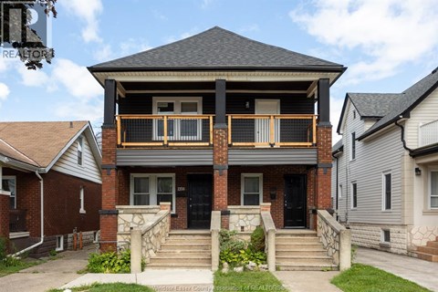 A house with a balcony and a black door.