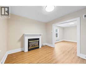 A living room with a fireplace and wood flooring.