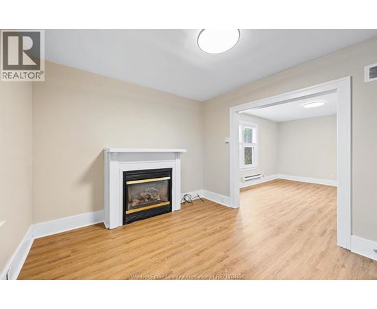 A living room with a fireplace and wood flooring.