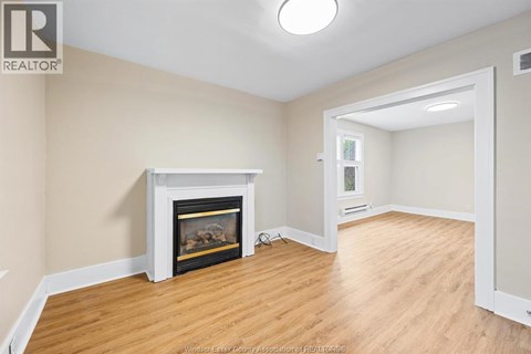 A living room with a fireplace and wood flooring.
