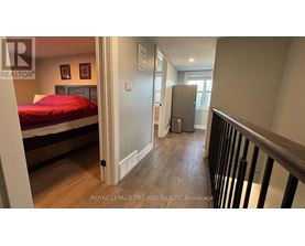 A bedroom with a bed, dresser, and a window.