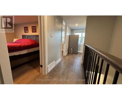A bedroom with a bed, dresser, and a window.