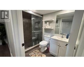 A bathroom with a toilet, sink, and shower.