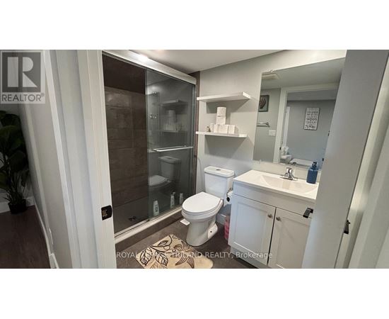 A bathroom with a toilet, sink, and shower.