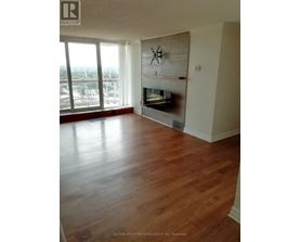 A living room with wood floors and a fireplace.
